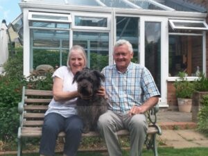 Mrs and Mr Gordon sitting on a bench with their dog Bilbo