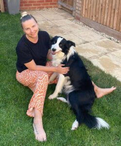 Trina sitting on the ground with her black and white collie called Cooper